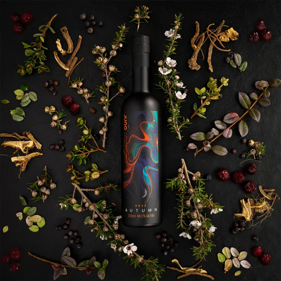 A bottle of Autumn 2024 Seasonal Gin with leaves and roots