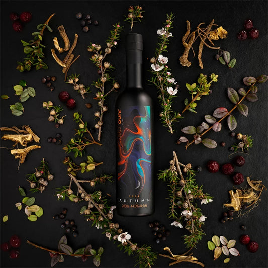 A bottle of Autumn 2024 Seasonal Gin with leaves and roots