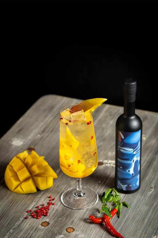 A mango Dive In cocktail with chilli and a bottle of Juno Summer 2024 Seasonal Gin