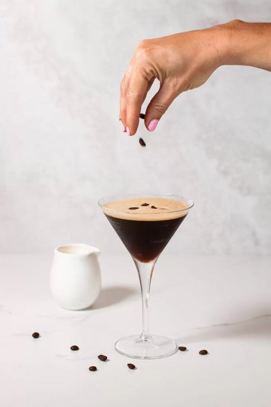 An Espresso Martini cocktail in a martini glass with coffee beans on top