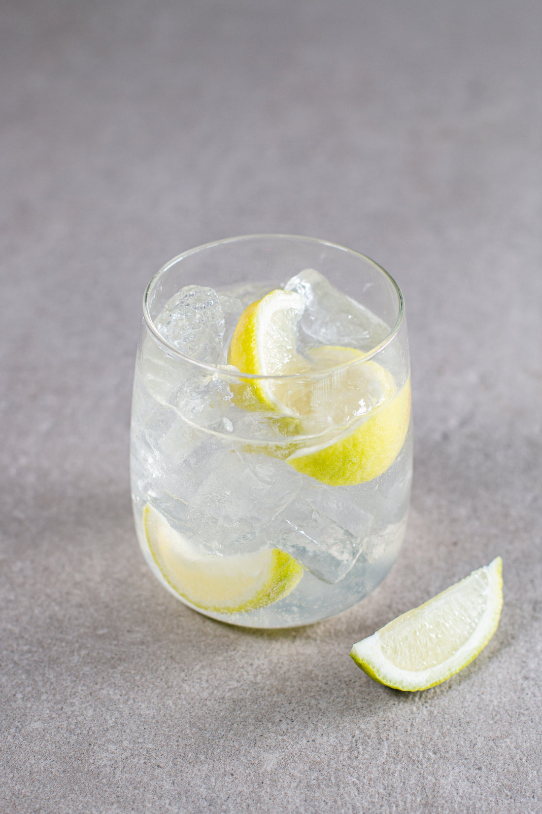 A Goddess and Saint cocktail in a short glass with lime wedge garnish