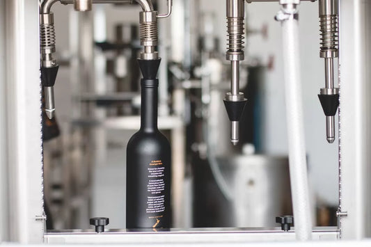 A bottle of Juno Extra Fine Gin on the silver bottle-filling machine