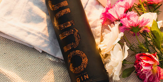 A Juno Extra Fine Gin bottle next to flowers