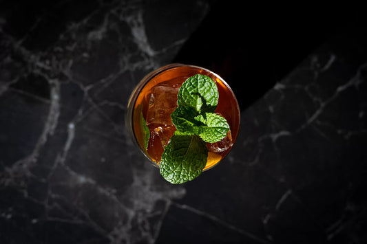 A cocktail seen from above with a mint garnish